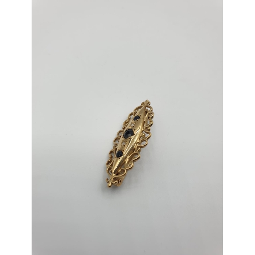 55 - 9ct gold boat shaped brooch consisting of a centre sapphire and a smaller sapphire and diamond eithe... 