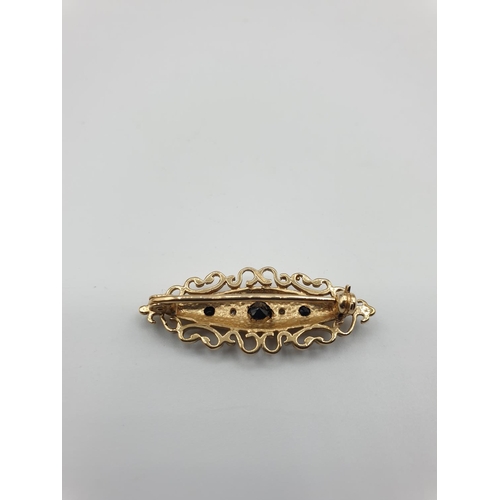 55 - 9ct gold boat shaped brooch consisting of a centre sapphire and a smaller sapphire and diamond eithe... 
