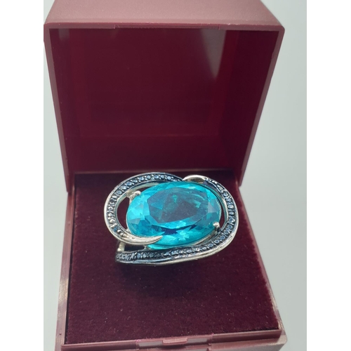283 - Silver ring having a large turquoise stone with a sweeping marquisette setting and surround. Clear 9... 