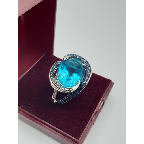 283 - Silver ring having a large turquoise stone with a sweeping marquisette setting and surround. Clear 9... 