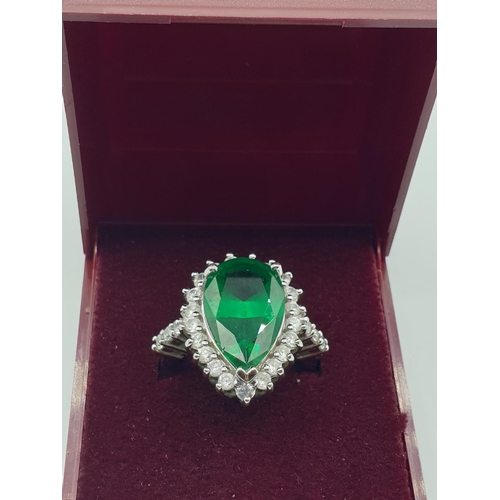 299 - Stone set silver ring. Having a pear shaped emerald green centre stone with a zirconia surround. Zir... 