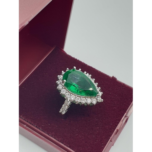 299 - Stone set silver ring. Having a pear shaped emerald green centre stone with a zirconia surround. Zir... 