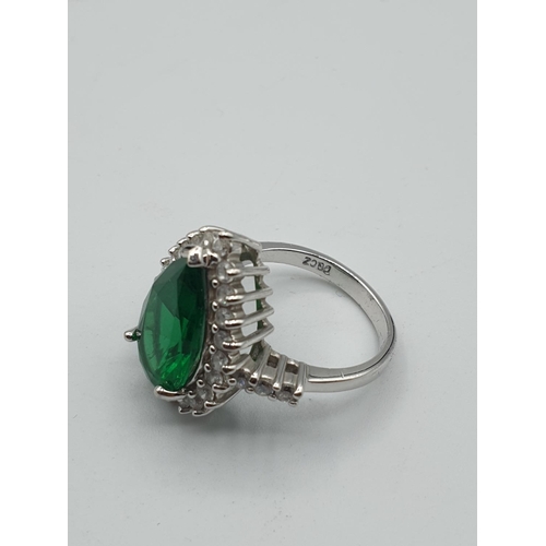 299 - Stone set silver ring. Having a pear shaped emerald green centre stone with a zirconia surround. Zir... 