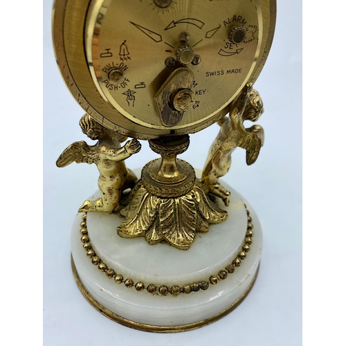 28 - Vintage 8 Day Swiza Clock with alarm on a marble base supported by 2 Cherubs, 14cm tall and weight 7... 