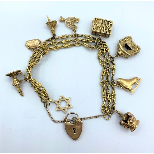 286 - An ornate 9ct Gold Charm Bracelet with 9 gold charms. Weighing 50.7g.