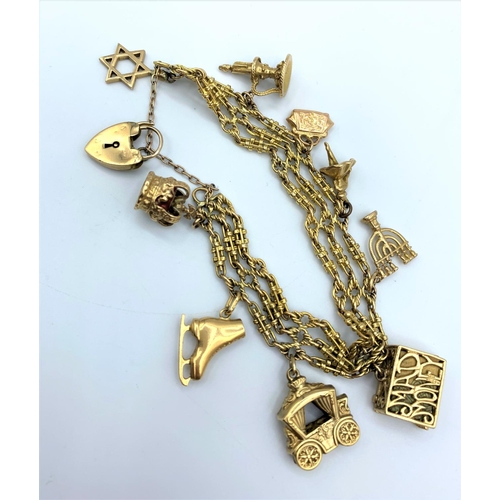 286 - An ornate 9ct Gold Charm Bracelet with 9 gold charms. Weighing 50.7g.