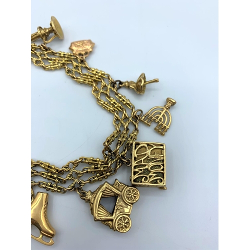 286 - An ornate 9ct Gold Charm Bracelet with 9 gold charms. Weighing 50.7g.