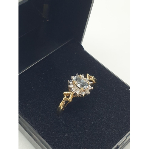 18 - Stone set 9ct Yellow gold Ring having an oval Topaz to centre of mount with a surround of small Diam... 