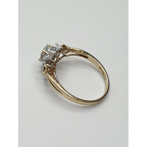 18 - Stone set 9ct Yellow gold Ring having an oval Topaz to centre of mount with a surround of small Diam... 