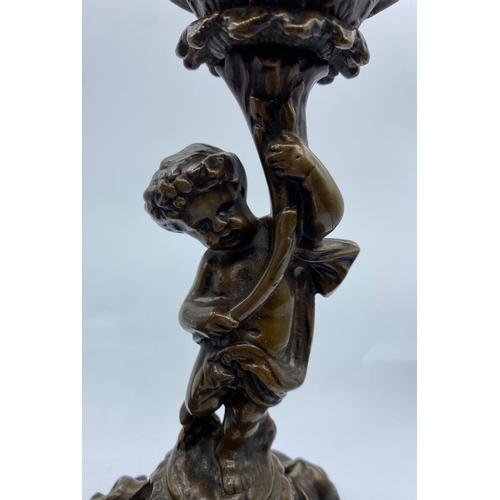 95 - A Pair of Antique Bronze Candlesticks with Cherubs, weight 2.9kg and 26cm tall (2)