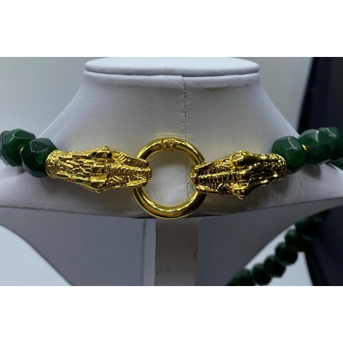 105 - A Necklace and matching Earrings of large, faceted, dark green Jade beads, with large Chinese dragon... 