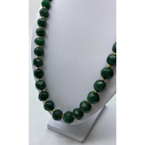 105 - A Necklace and matching Earrings of large, faceted, dark green Jade beads, with large Chinese dragon... 