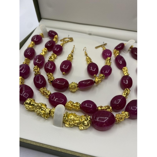 99 - A Ruby and 22ct Gold plated 'Pixiu' long Necklace, Bracelet and Earrings set in a presentation box