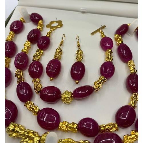 99 - A Ruby and 22ct Gold plated 'Pixiu' long Necklace, Bracelet and Earrings set in a presentation box