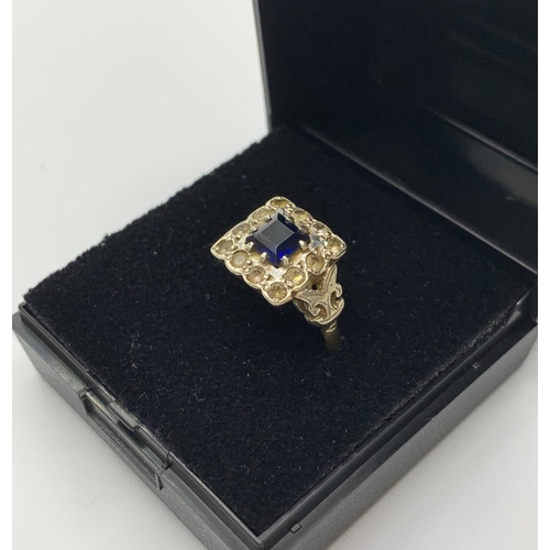 113 - 9CT Gold Ring stone set with square Sapphire to centre and a 10 Zirconia surround, 3.3g approx and s... 