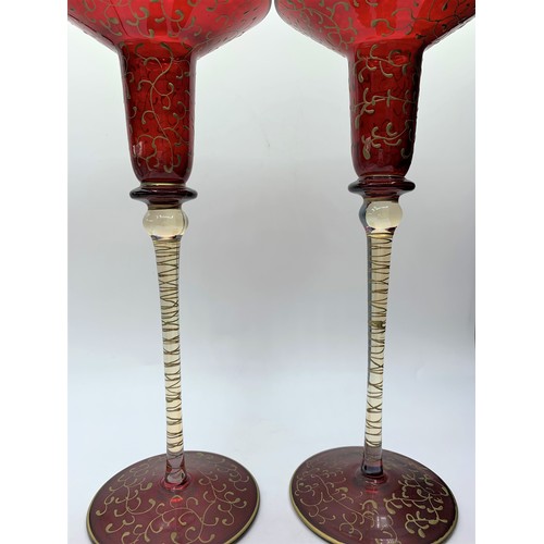 146 - A pair of Blown Cranberry Glass Candlesticks with glass and gold stems, 25cm tall (2)