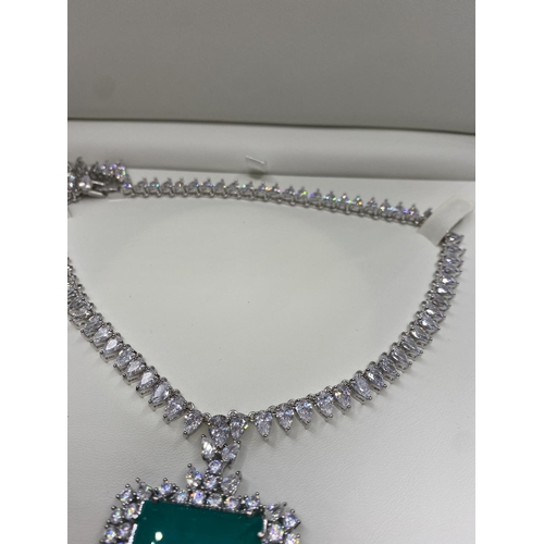 24 - Attractive necklace with simulated emerald (36x25mmm) and sapphires marked 18KGL, designed and signe... 