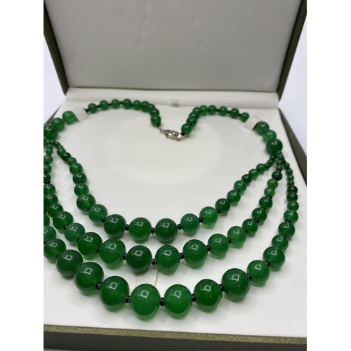 36 - A graduating green jade necklace in a presentation box.