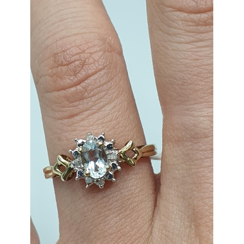 365 - Stone set 9ct Yellow gold Ring having an oval blue Topaz to centre of mount with a surround of small... 