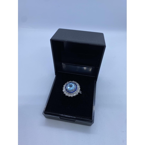 278 - 18ct White Gold Ring with Aqua Marine Centre Stone Surrounded by Sapphires and Diamonds, 6.8g, Size ... 