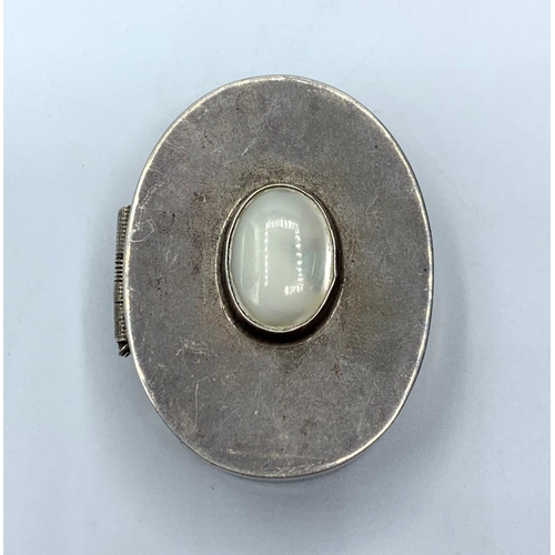 311 - Silver pill box with mother of pearl decorative centre stone, weighs 40g and is 4.5cms tall