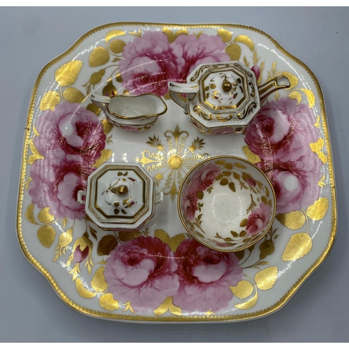 594 - An interesting miniature set of teapot, sugar box, bowl and creamer on a Ribbon & wreath shape plate... 