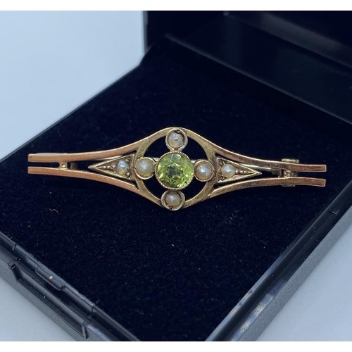 627 - 9ct Gold bar brooch having peridot centre stone with a seed pearl quartet surround.