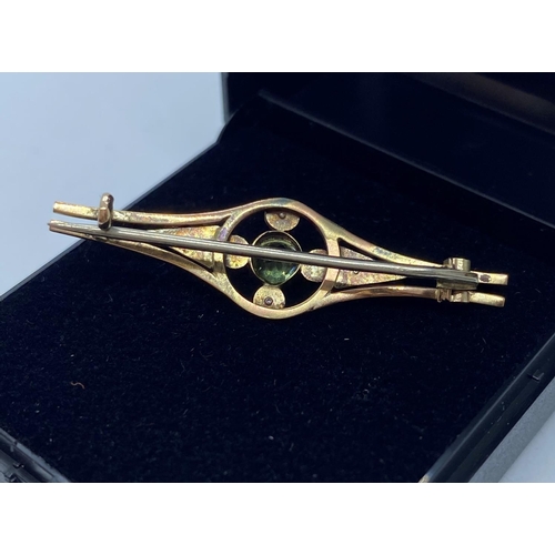 627 - 9ct Gold bar brooch having peridot centre stone with a seed pearl quartet surround.