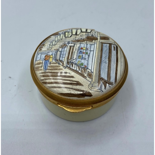 666 - Ornate enamelled pill box with a picture of Prince Arcade, Piccadilly London ,4cm diameter.