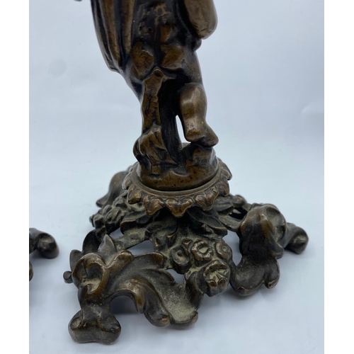 335 - A Pair of Antique Bronze Candlesticks with Cherubs, weight 2.9kg and 26cm tall (2)