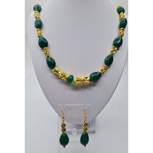 101 - An emerald and 18k gold filled foo dogs necklace and matching earrings set. Necklace length 77cm. To... 