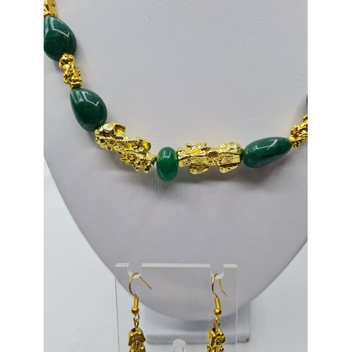 101 - An emerald and 18k gold filled foo dogs necklace and matching earrings set. Necklace length 77cm. To... 