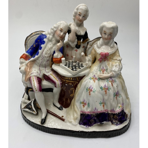 665 - Ceramic statue of a Dandy Playing chess with his lady admirers, 10x14cm