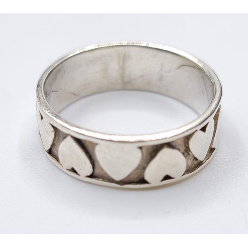 306 - Silver ring having raised hearts covering the entire band. Stamped 925. Size O/P