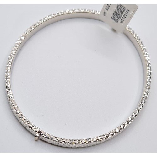 296 - 9CT WHITE GOLD DIAMOND CUT HINGED BANGLE. WEIGHT 6G