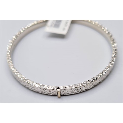 296 - 9CT WHITE GOLD DIAMOND CUT HINGED BANGLE. WEIGHT 6G