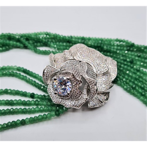 54 - An impressive six row faceted emerald necklace with a white metal and cubic zirconia ornamental rose... 