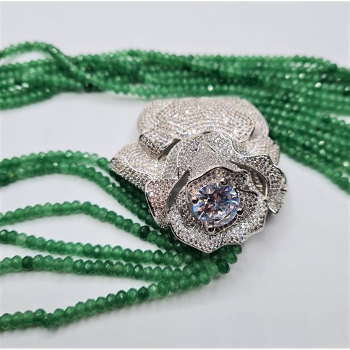 54 - An impressive six row faceted emerald necklace with a white metal and cubic zirconia ornamental rose... 