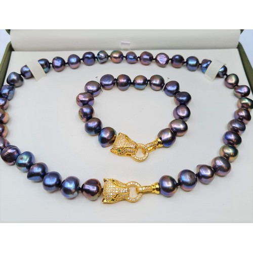 22 - A Polynesian black pearl necklace and bracelet set with Cartier style yellow metal (untested) and cl... 