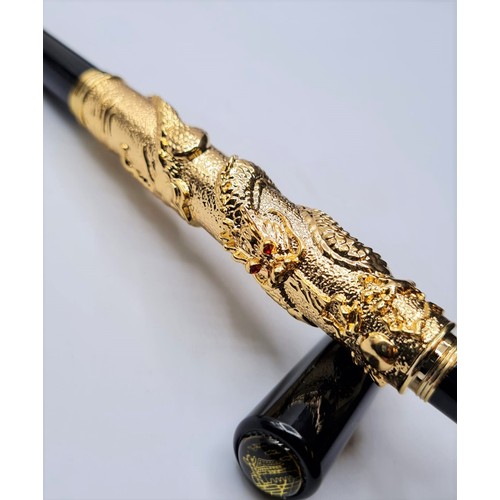 53 - A Chinese writing black pen with an 18ct gold filled Chinese dragon with red Gem eyes. Length 13cm, ... 