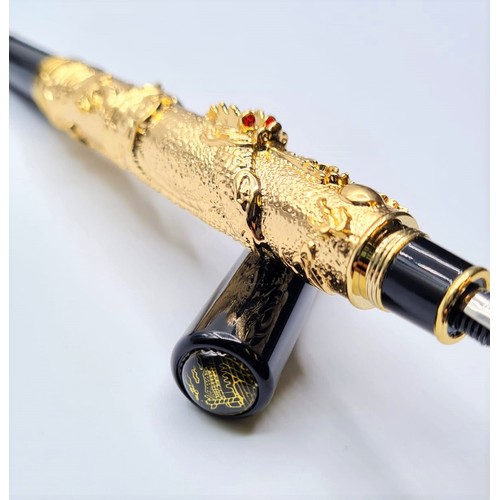 53 - A Chinese writing black pen with an 18ct gold filled Chinese dragon with red Gem eyes. Length 13cm, ... 