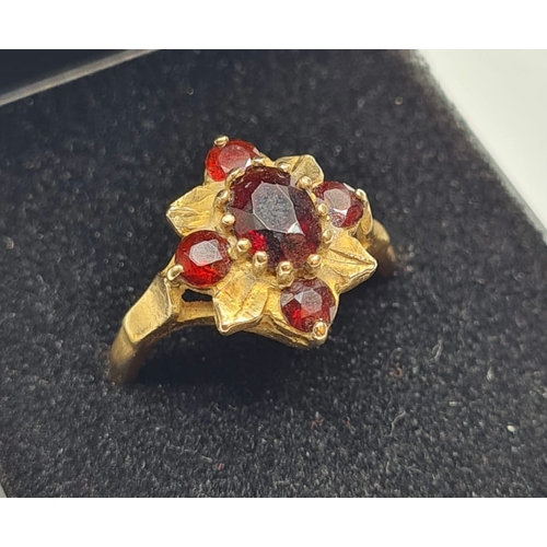 139 - 9ct Gold Ring with Five Garnets in a Flower Head Formation. Size O/P, 3.6 grams approx.