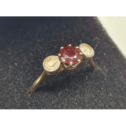 172 - 9ct gold three stone ring having a centre garnet with a white stone either side. Garnet mounted in p... 