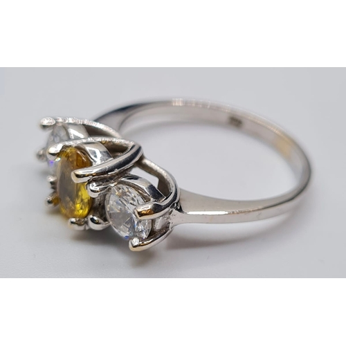 176 - 18ct white gold three stone ring. Having a yellow topaz oval centre stone flanked  by two large clea... 