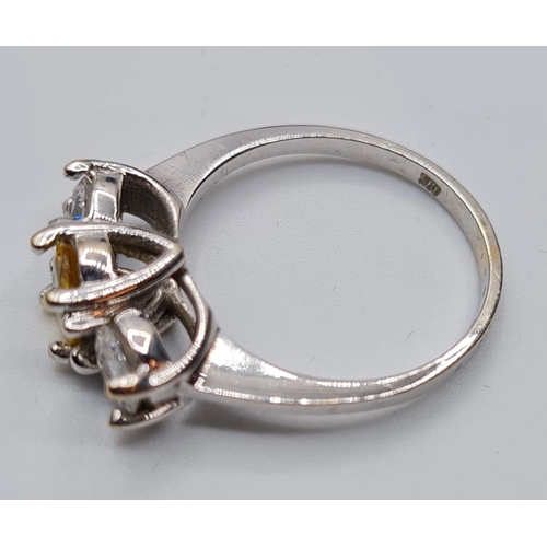 176 - 18ct white gold three stone ring. Having a yellow topaz oval centre stone flanked  by two large clea... 