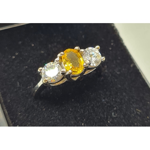 176 - 18ct white gold three stone ring. Having a yellow topaz oval centre stone flanked  by two large clea... 