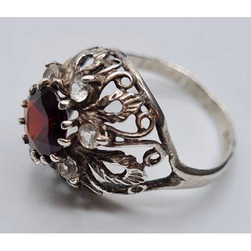 437 - Stone Set Silver Ring having Centre Garnet and 6 Zirconia's Surround Set on a Silver Filigree Mount.... 