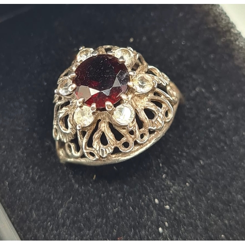 437 - Stone Set Silver Ring having Centre Garnet and 6 Zirconia's Surround Set on a Silver Filigree Mount.... 