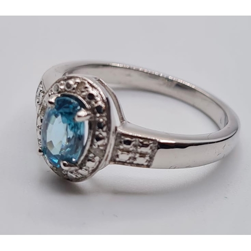 451 - Stone Set Silver Ring Having a Centre Stone the Colour of Blue Topaz, Oval Faceted Form, Size P/Q.