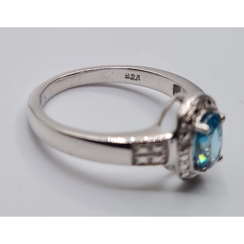 451 - Stone Set Silver Ring Having a Centre Stone the Colour of Blue Topaz, Oval Faceted Form, Size P/Q.